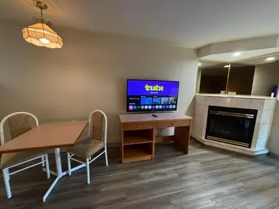 a living room with a table and a tv and a fireplace at Western Budget Motel #1 & 2 Whitecourt in Whitecourt