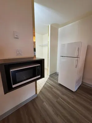 a kitchen with a microwave and a refrigerator at Western Budget Motel #1 & 2 Whitecourt in Whitecourt