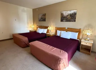 a hotel room with two beds and two lamps at Western Budget Motel Ponoka in Ponoka