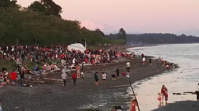 a large crowd of people on a beach at White Rose House in White Rock