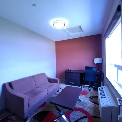 a living room with a couch and a desk at Wabasca Inn in Wabasca