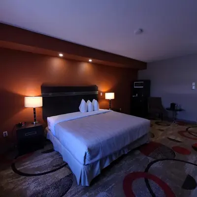a bedroom with a large white bed with two lamps at Wabasca Inn in Wabasca