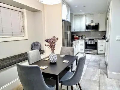 a kitchen with a dining room table and chairs at New Urban Modern Main Street House in Vancouver