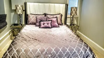 a bedroom with a large bed with purple pillows at New Urban Modern Main Street House in Vancouver