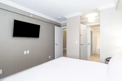 a bedroom with a bed and a tv on the wall at Sandman Hotel and Suites Abbotsford in Abbotsford
