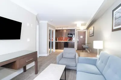 a living room with a couch and a tv at Sandman Hotel and Suites Abbotsford in Abbotsford