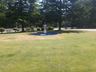 a park with a fountain in the middle of a field at Fuller Lake Chemainus Motel in Chemainus