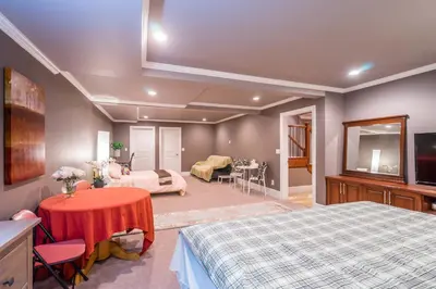 a bedroom with two beds and a living room at Vancouver Yuelai Guesthouse in Coquitlam