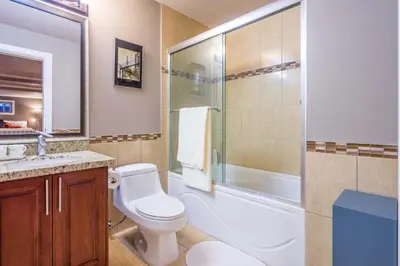 a bathroom with a toilet and a shower and a sink at Vancouver Yuelai Guesthouse in Coquitlam