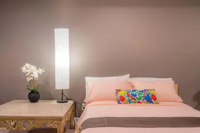 a bedroom with a bed and a table with a lamp at Vancouver Yuelai Guesthouse in Coquitlam