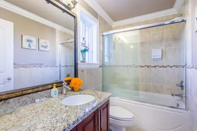 a bathroom with a sink and a shower and a toilet at Vancouver Yuelai Guesthouse in Coquitlam