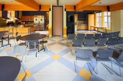 a room with tables and chairs and a kitchen at HI Banff Alpine Centre - Hostel in Banff