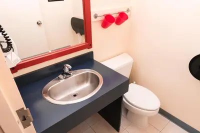 a bathroom with a sink and a toilet and a mirror at HI Banff Alpine Centre - Hostel in Banff