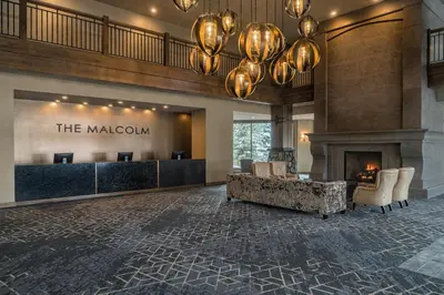 a lobby with a reception desk and a fireplace at The Malcolm Hotel in Canmore