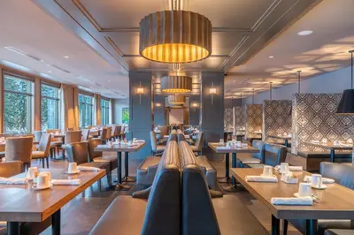 a restaurant with tables and chairs and windows at The Malcolm Hotel in Canmore