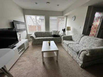 a living room with two couches and a tv at Albion Stay in Maple Ridge District Municipality