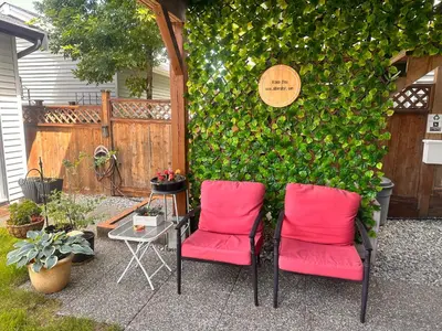 two red chairs sitting in front of a green wall at Albion Stay in Maple Ridge District Municipality