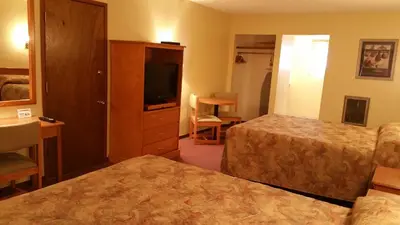 a hotel room with two beds and a flat screen tv at Yellowhead Motel in Valemount