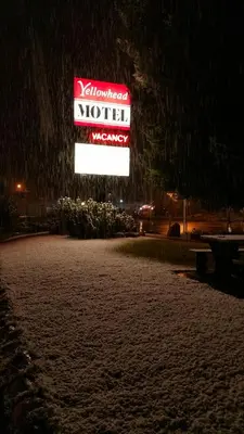 a sign for a motel in the snow at night at Yellowhead Motel in Valemount