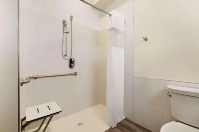 a bathroom with a shower and a toilet at Days Inn by Wyndham 100 Mile House in One Hundred Mile House