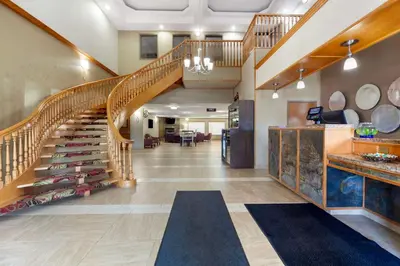 a large hallway with a staircase and a living room at Best Western Grande Prairie in Grande Prairie