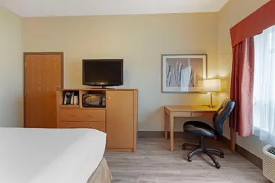 a hotel room with a bed and a desk with a television at Best Western Grande Prairie in Grande Prairie