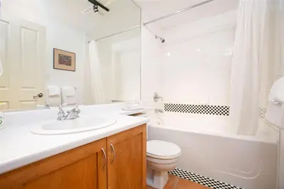 a bathroom with a sink and a tub and a toilet at Alpenglow Lodge by Bill in Whistler