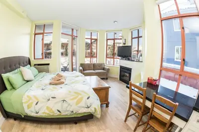 a bedroom with a bed and a living room at Alpenglow Lodge by Bill in Whistler