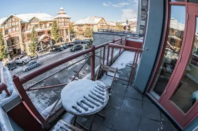a bench sitting on a balcony with snow on it at Alpenglow Lodge by Bill in Whistler