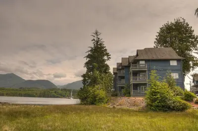 a house on the shore of a body of water at Waters Edge Shoreside Suites in Ucluelet