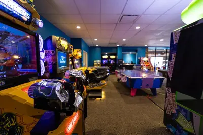 a room with several arcade games and a pool table at The Thompson Hotel in Kamloops