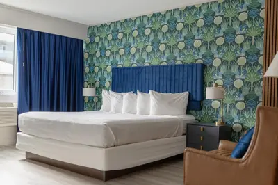 a bedroom with a bed with a blue and green wallpaper at The Thompson Hotel in Kamloops