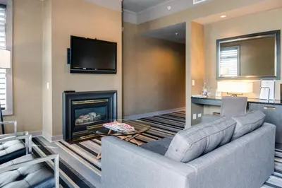 a living room with a couch and a fireplace at Hotel Arts Kensington in Calgary