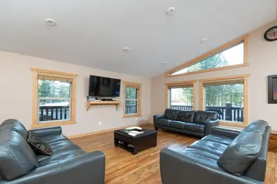 a living room with leather furniture and a flat screen tv at Mama Bear in Valemount