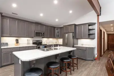 a kitchen with wooden cabinets and a island with bar stools at Aspen in Valemount