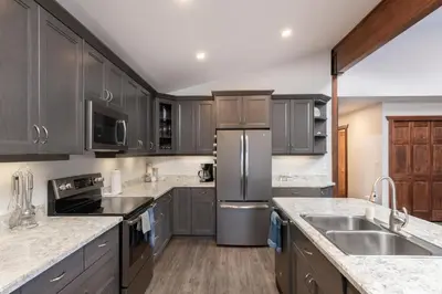 a kitchen with gray cabinets and stainless steel appliances at Aspen in Valemount