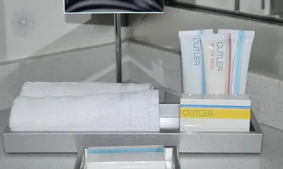 a shelf with towels and books on a bathroom counter at Inn At The Quay in New Westminster