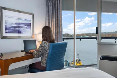 a woman sitting at a desk with a laptop at Inn At The Quay in New Westminster