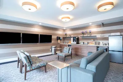a living room with a couch and a kitchen at Sandman Signature Calgary Airport Hotel in Calgary