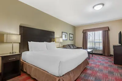 a hotel room with a large bed and a couch at Best Western Plus Red Deer Inn & Suite in Red Deer