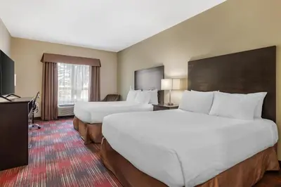 a hotel room with two beds and a television at Best Western Plus Red Deer Inn & Suite in Red Deer