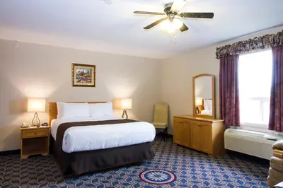 a hotel room with a bed and a window at West Country Inn in Drayton Valley