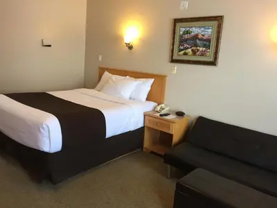 a hotel room with a bed and a couch at West Country Inn in Drayton Valley