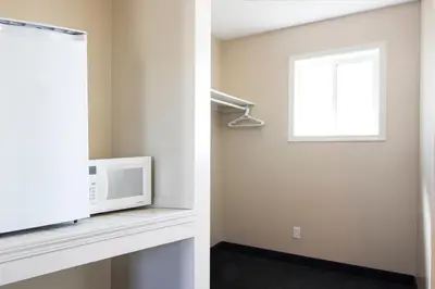 a living room with a microwave and a window at West Country Inn in Drayton Valley