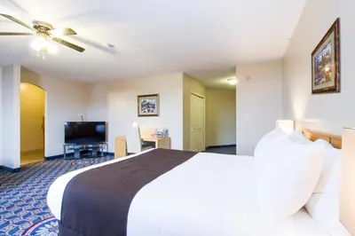 a hotel room with a large bed and a flat screen tv at West Country Inn in Drayton Valley