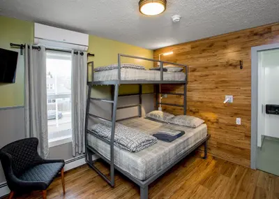 a bedroom with bunk beds in a room with a window at Jasper Downtown Hostel in Jasper