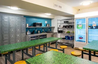a kitchen with green tables and benches in a room at Jasper Downtown Hostel in Jasper