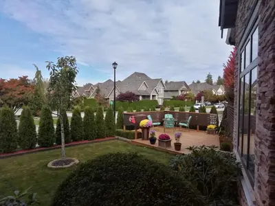 a backyard with a wooden deck with chairs and plants at Sunny Island by White Rock B&B in White Rock