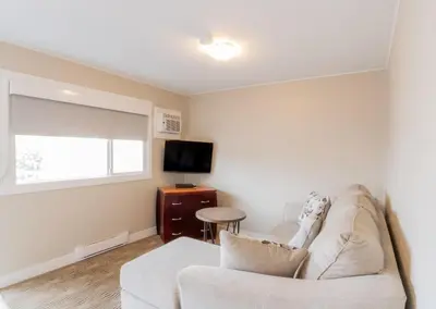 a living room with a couch and a tv at Scott's Inn & Suites in Kamloops