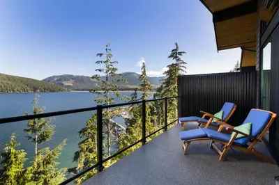 two chairs on a balcony with a view of a lake at Avatar by Eagle Reach Properties in Port Renfrew